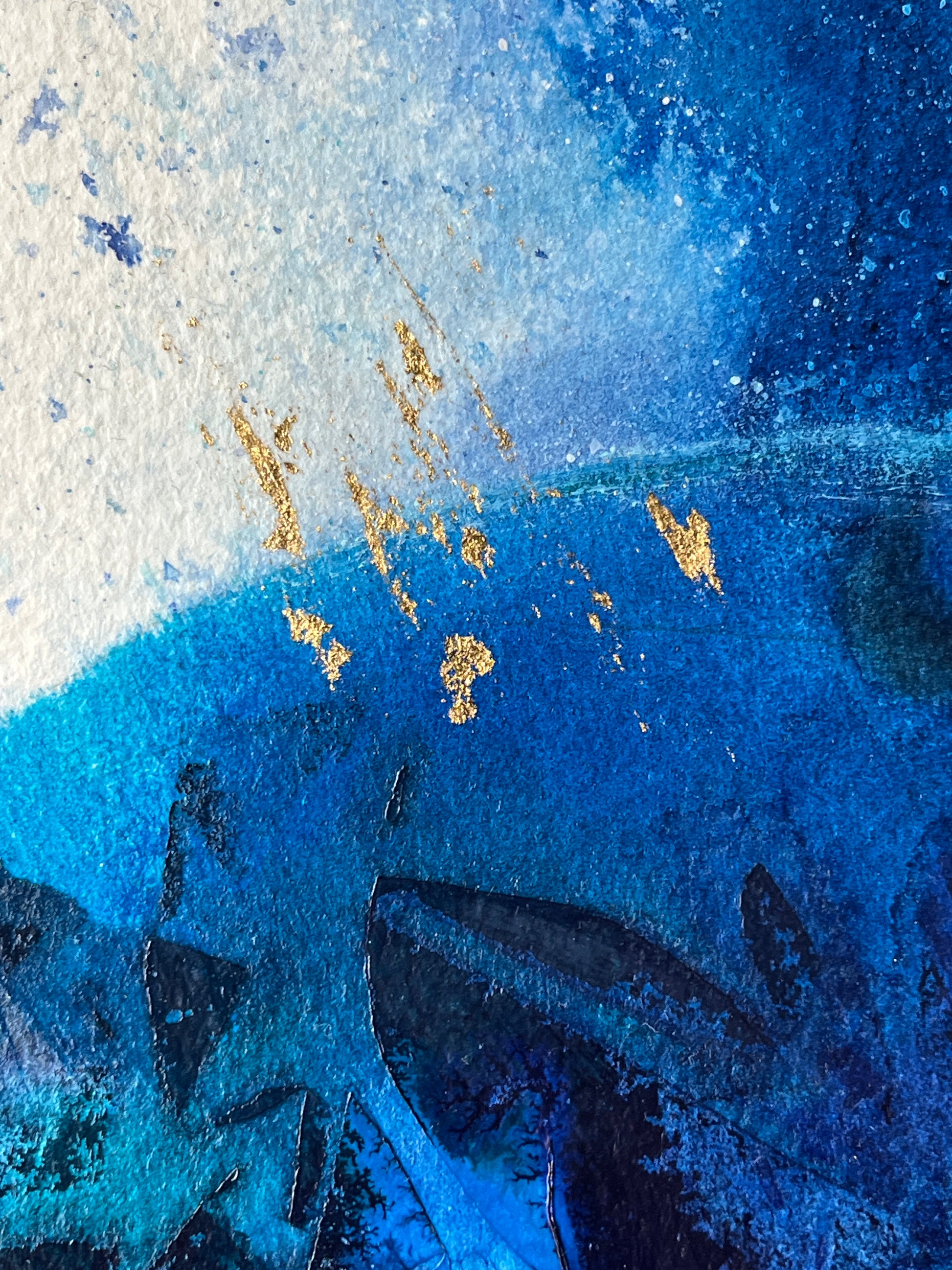 A close-up of an abstract painting with blue tones, textured layers and gold leaf.