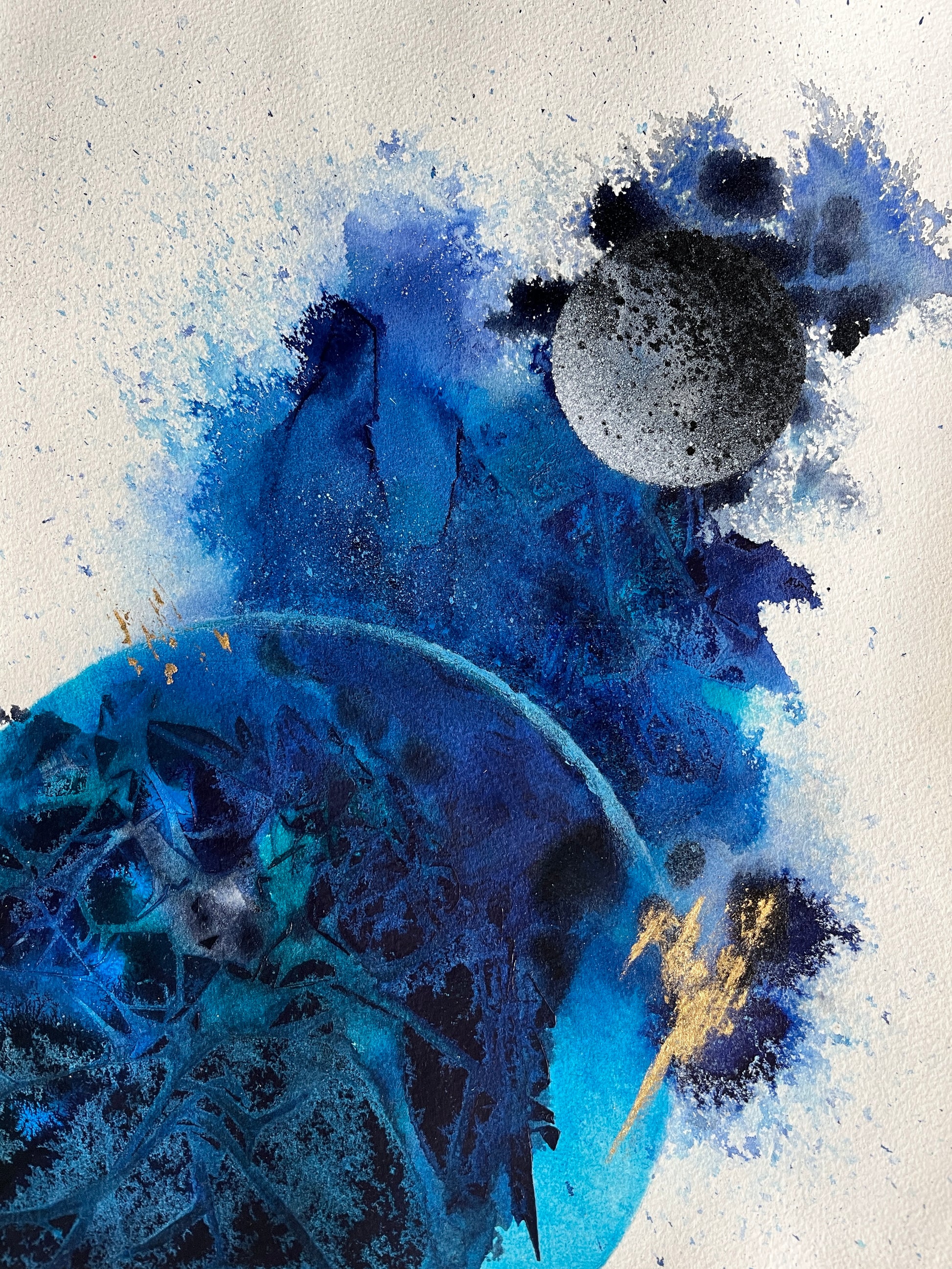 Abstract painting of the earth and the moon in blue colors and with gold leaf.